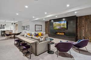 Living area featuring carpet floors, a large fireplace, and recessed lighting