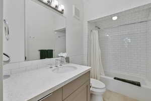 Full bathroom with vanity, shower / bath combo, and tile patterned flooring