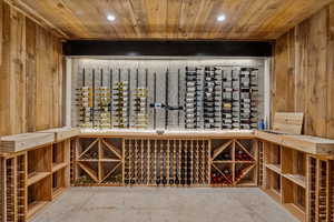 Wine room featuring wooden ceiling, wooden walls, and recessed lighting