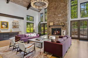 Living area featuring wood finished floors, plenty of natural light, french doors, high vaulted ceiling, and a wooden ceiling with exposed beams