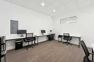 Office featuring electric panel, carpet floors, a drop ceiling, and recessed lighting