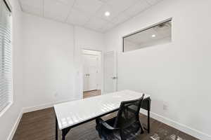 Home office featuring a paneled ceiling, wood finished floors, and recessed lighting