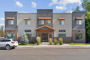 View of front of home featuring french doors, brick siding, and stucco siding