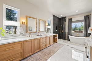 Bathroom with marble finish flooring, double vanity, tiled shower, a freestanding bath, and recessed lighting