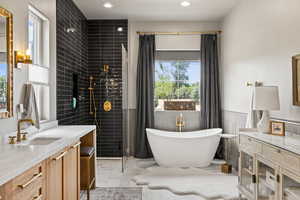 Bathroom featuring vanity, a soaking tub, marble look tile flooring, tiled shower, and recessed lighting