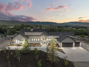 Modern farmhouse style home featuring a mountain view, a garage, concrete driveway, and a chimney
