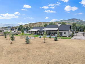 Rear view of property with a mountain view, a chimney, and a patio