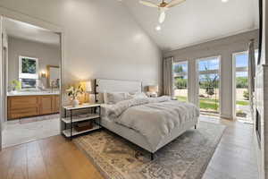 Bedroom featuring light wood finished floors, high vaulted ceiling, recessed lighting, and ensuite bathroom