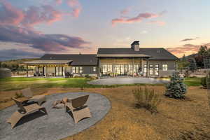 Rear view of property with a patio, a metal roof, a chimney, a yard, and french doors