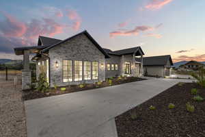 View of front of house featuring stone siding and driveway