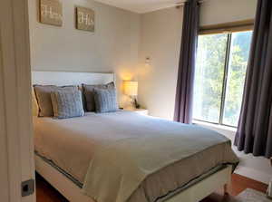 Bedroom with multiple windows and wood finished floors