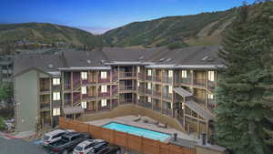 Aerial view at dusk of view of pool area and a mountain view