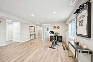 Workout room with recessed lighting and light wood-style flooring