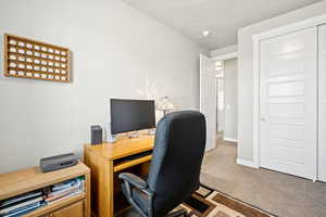 Carpeted home office featuring baseboards