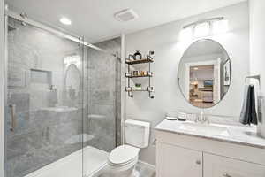 Bathroom featuring connected bathroom, vanity, a stall shower, and recessed lighting