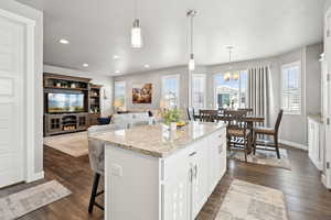 Kitchen featuring plenty of natural light, a kitchen bar, a center island, white cabinets, and recessed lighting