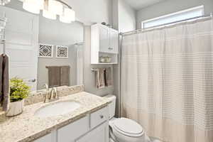 Full bathroom with vanity and a shower with shower curtain
