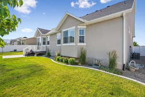 View of home's exterior with stucco siding, a patio area, a deck, and a shingled roof