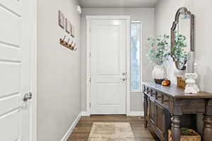 Entryway with dark wood-style floors and baseboards