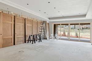 Living area with a raised ceiling and unfinished concrete floors