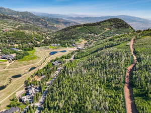 View of property location with a mountainous background and a heavily wooded area