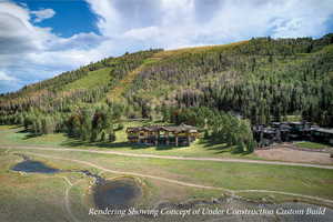 Aerial view of property and surrounding area featuring a forest