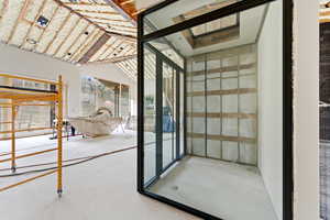 Doorway with concrete floors and vaulted ceiling