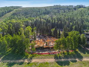 Aerial view of property and surrounding area featuring a heavily wooded area