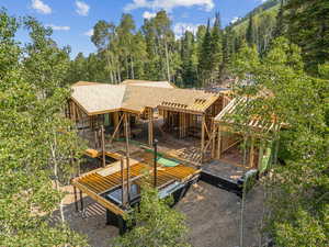 Back of house with a shingled roof and a wooden deck