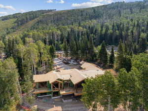 Aerial view of property and surrounding area featuring a forest
