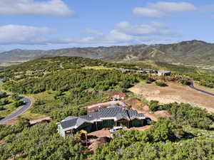 Aerial view of property and surrounding area featuring a mountain backdrop