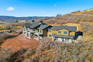 Back of property featuring a chimney, a patio, and a mountain view