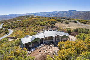 View of subject property featuring a mountain backdrop and a forest