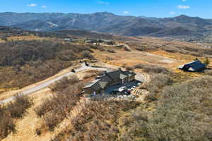 Aerial view of property and surrounding area featuring a mountain backdrop