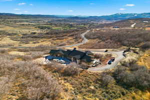 Aerial view of property and surrounding area with a mountain backdrop