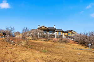Rear view of property with a chimney and a balcony