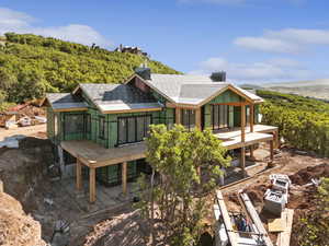 Back of property with a shingled roof and a patio