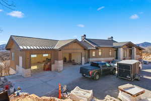 View of front of property with a chimney, a shingled roof, board and batten siding, and a garage