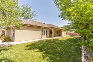 Rear view of house with stucco siding and a patio area