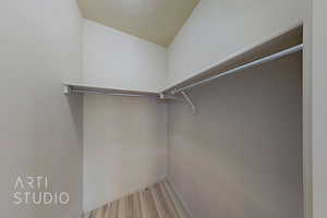 Spacious closet with wood finished floors and lofted ceiling