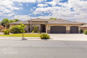 Mediterranean / spanish-style home with a garage, concrete driveway, a front lawn, stucco siding, and stone siding