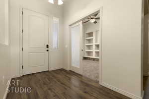 Foyer entrance with dark wood finished floors and a ceiling fan