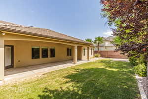 Rear view of house with stucco siding and a patio area