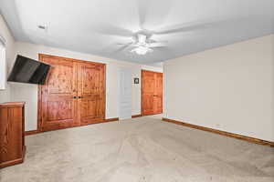Unfurnished bedroom featuring light colored carpet and ceiling fan
