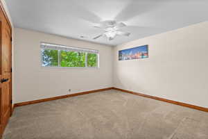 Empty room featuring carpet floors and ceiling fan