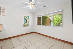 Spare room with ceiling fan and light tile patterned floors