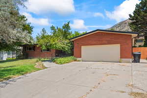 View of front of home with brick siding, concrete driveway, and a mountain view