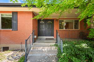 View of exterior entry with brick siding