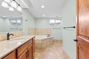 Bathroom with vanity, healthy amount of natural light, a bath, tile patterned flooring, and recessed lighting