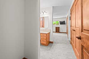 Corridor with light colored carpet and baseboards
